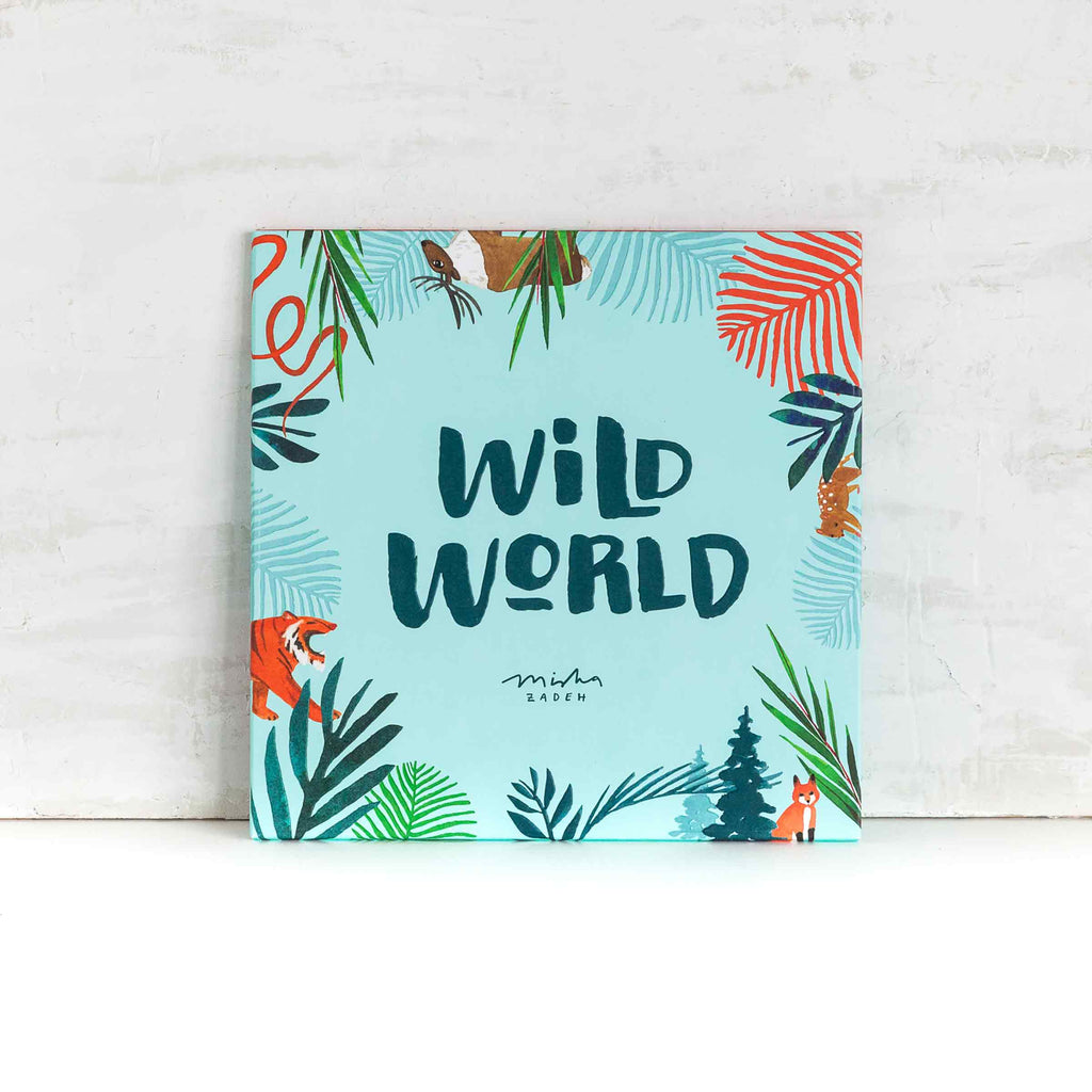 Overhead shot of wrapped packages with Misha Zadeh Wild World Gift Wraps, embellished with silk ribbon and colorful gift tags