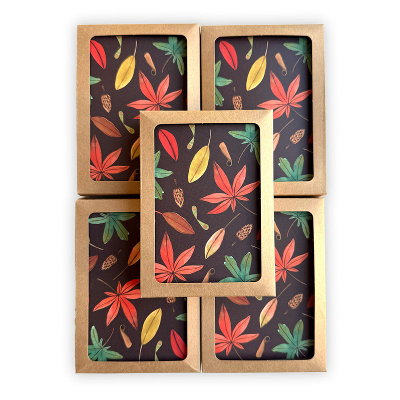 five stacked, boxed notecards featuring a hand painted autumn leaf pattern on a deep chocolate brown background.