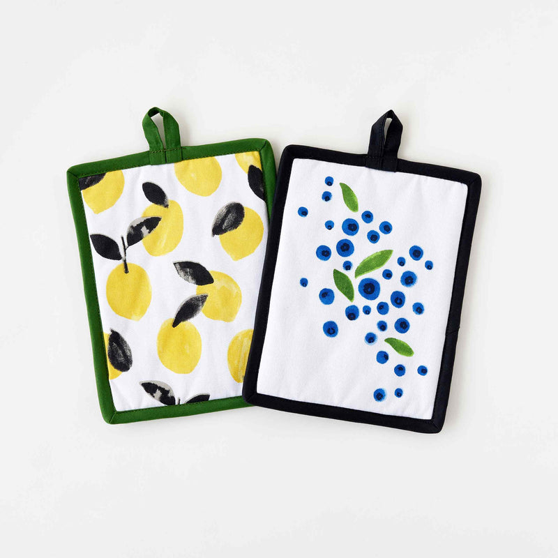 Two Hot Pads from Misha Zadeh Fantastical Fruit Collection. Lemons on a Green Backing and Blueberries on a Black Backing