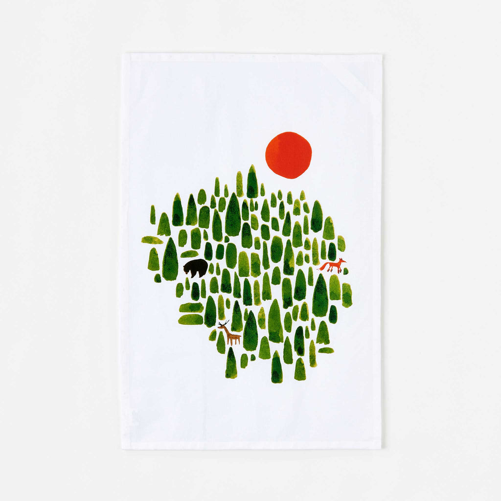 Misha Zadeh for 180 Degrees. Winter Forest: a vibrant wintery print screen printed on bright white tea towel. Winter Forest includes abstracted evergreen trees, a black bear, an orange fox, and a tawny deer and a large orange sun.