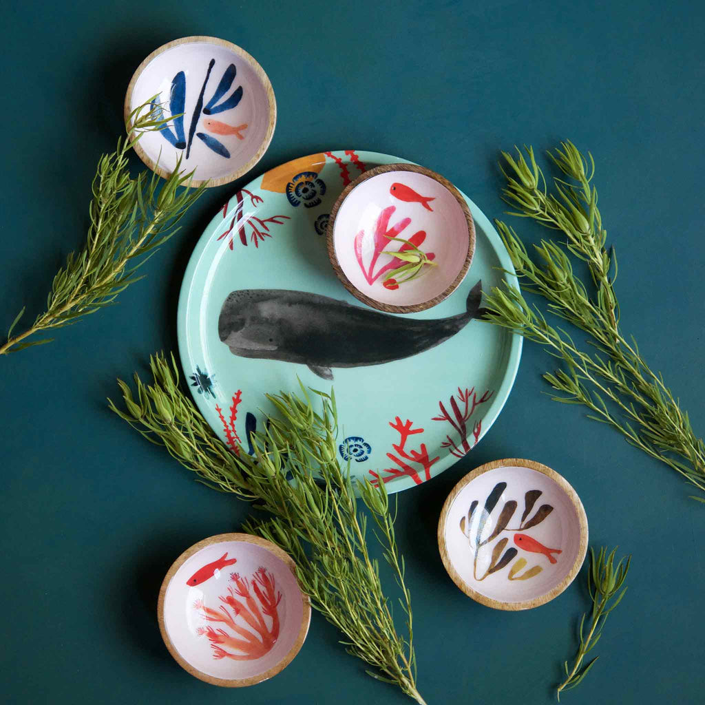 Misha Zadeh Whale Tray and Mango Wood Fish Bowls for 180 Degrees. Gray whale, red and blue coral and seaweed bring lush pops of color against a vibrant sea green background