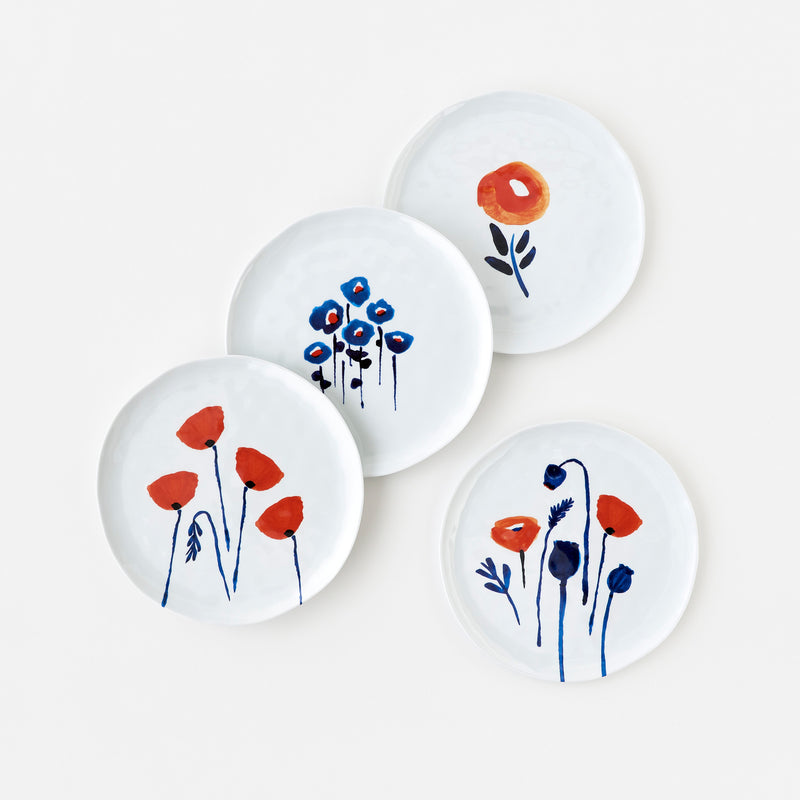 Orangey Red Poppies and Inky Blue leaves and stems on crisp white background plates. By artist Misha Zadeh