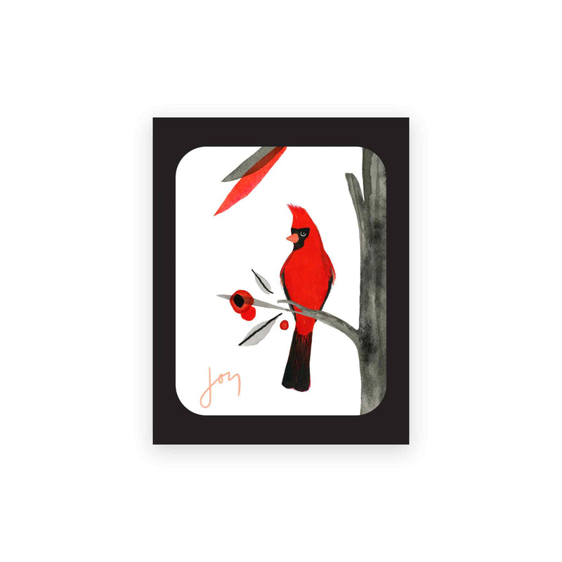 Misha Zadeh Boxed Holiday Cards. Features an acrylic ink painting of a vibrant red cardinal with inky washes of branches, leaves, and bright red berries Exterior greeting is "Joy". Interior is blank. Set of 8 folded cards
