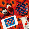 Mod Print Ceramic Trinket Dish Appetizer dish, Mia Poppies Creamer and Salt and Pepper Set, and an original tulips on blue painting by Misha Zadeh, all atop her Country Poppies Kitchen Towel in Red