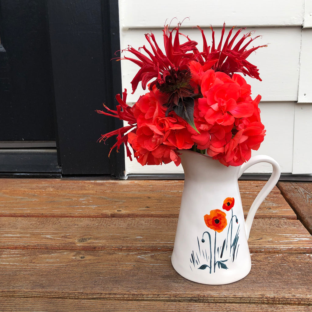 Misha Zadeh's Mia Poppies Creamer used as a vase and filled with Red Bee Balm and Coral Geraniums.